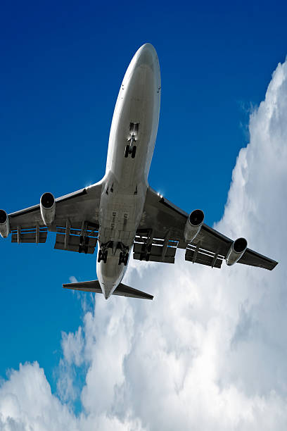 istock XL jumbo jet airplane landing with storm cloud 136919707
