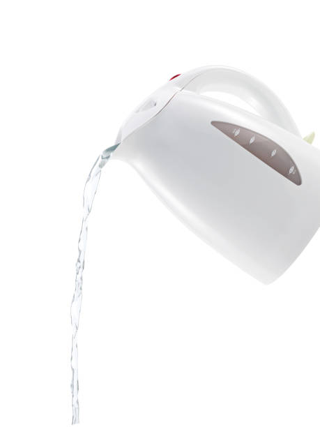 Pouring water from an electric kettle on white background