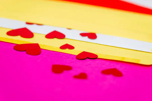 red little hearts coming out from envelope isolated on pink background with copy space, loveletter concept, close-up