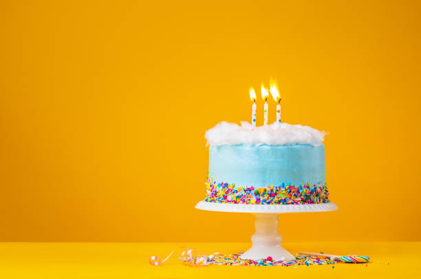 Blue Birthday Cake with three Candles over a yellow Background Blue Birthday cake with three  Birthday candles and candy sprinkles over a yellow background. birthday cake photos stock pictures, royalty-free photos & images
