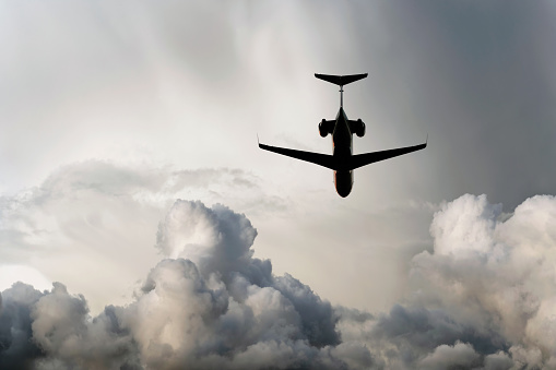 corporate jet airplane in silhouette flying in storm (XXL)