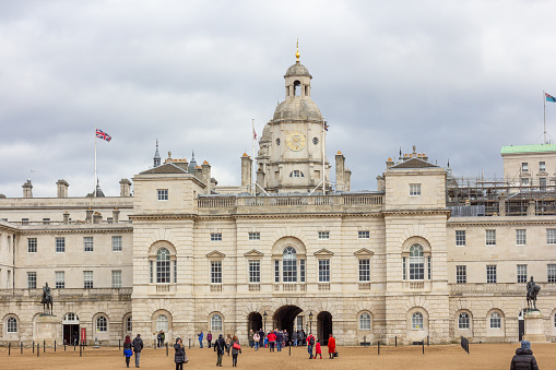 Horse Guards Building in City of Westminster, London. Tourists are seen walking on Horse Guards Parade. Built in 1759 in the Georgian Style, it houses the Household Cavalry Museum.