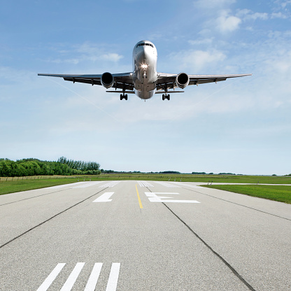 jet airplane landing on runway with bright sky, square frame (XL)
