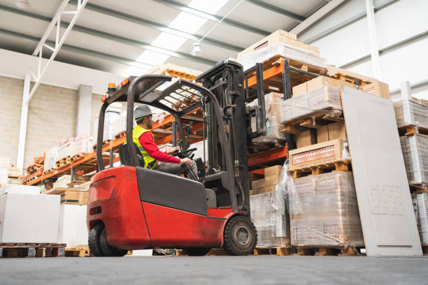 istock Caucasian male sitting on a forklift working in a warehouse 1369202226