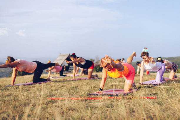 istock Big group of women going yoga class outdoors on a hill 1369205669