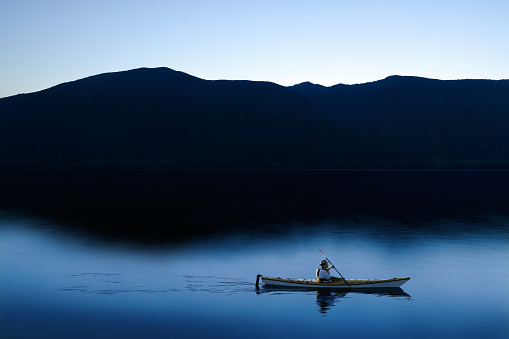 single man kayaking on serene mountain lake at twilight (XXL)