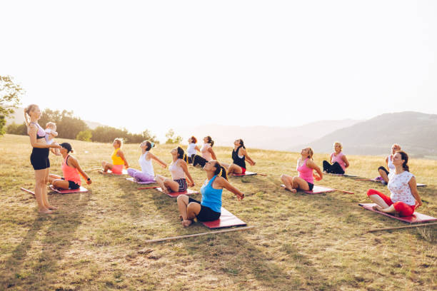 istock Big group of women going yoga class outdoors on a hill 1369206002