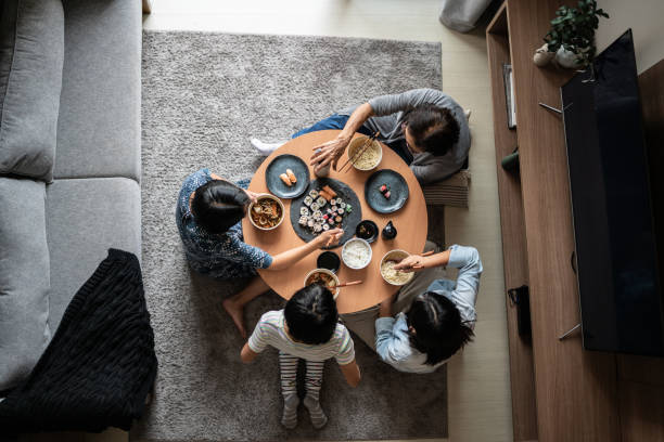 high angle view of a family eating japanese food at home - sushischotel stockfoto's en -beelden