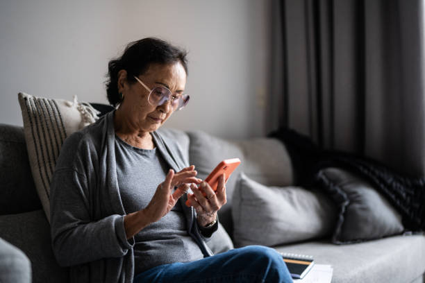 istock Senior woman using smartphone at home 1369206777