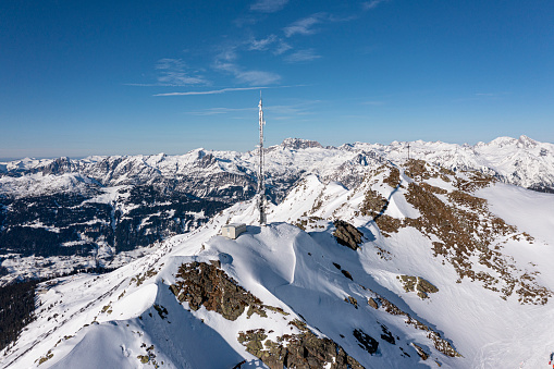 Frozen communication tower and a summit cross on top of a mountain. Vorarlberg, Montafon