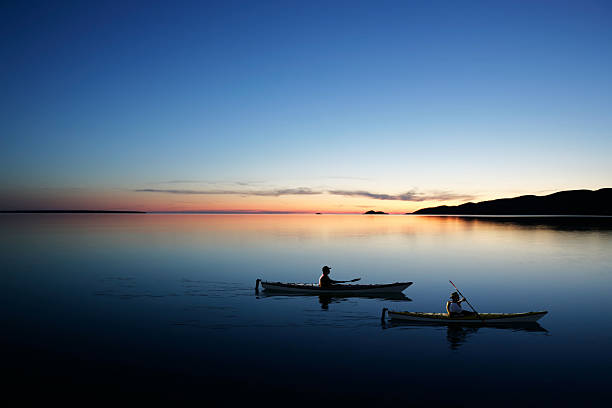 XXL twilight kayakers father and son kayaking on serene lake at twilight (XXL) north stock pictures, royalty-free photos & images