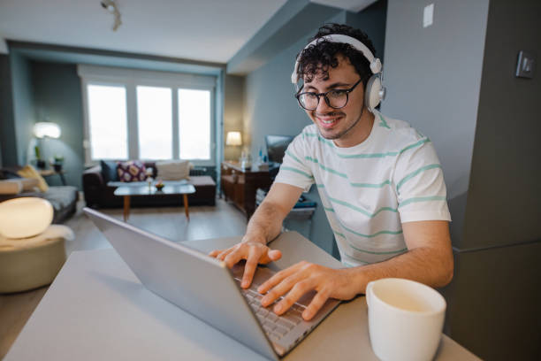 istock Young man uses laptop and surfing the net 1369206873