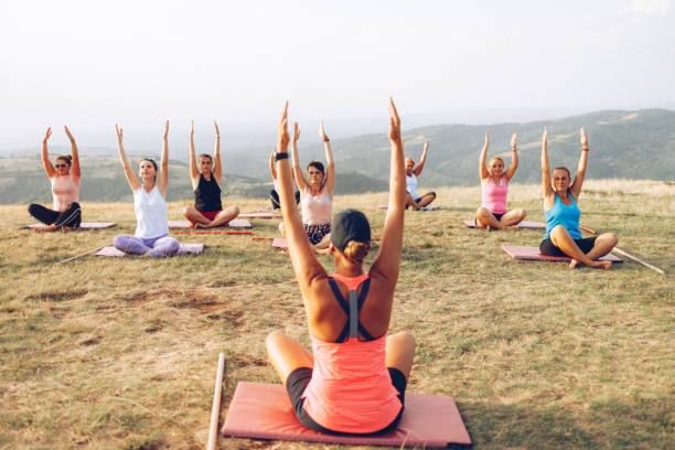istock Big group of women going yoga class outdoors on a hill 1369207431