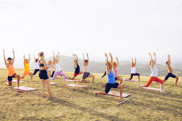 istock Big group of women going yoga class outdoors on a hill 1369208106
