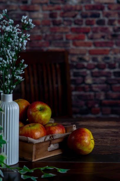 istock Apple on a wooden table as backdrop.background red brick wall. 1369208177