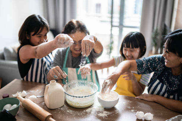 istock Happy family making mess while preparing a cake at home 1369209428