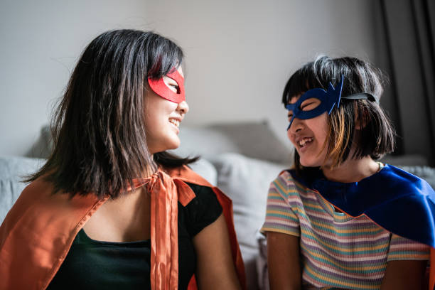 istock Sisters playing as superheroes at home 1369209509