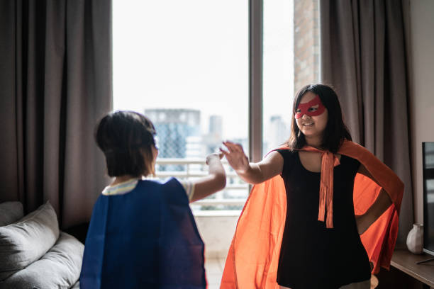 istock Sisters playing as superheroes at home 1369209528
