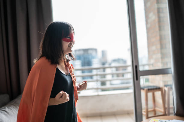 One person of aged 40-44 years old who is beautiful with black hair caucasian female rock musician bending in front of white background wearing mask - disguise who is imagination and celebrating who is doing air guitar and holding guitar