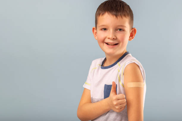 istock Vaccinated boy gesturing with thumbs up, showing hand with plaster cast after injection of coronavirus vaccine. Start of vaccination campaign for children and teenagers. Successful Covid-19 vaccination 1369209603