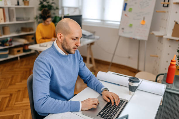 istock Businessman using laptop on desk in office 1369211293