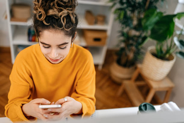 istock Businesswoman using smart phone at desk in office 1369211345
