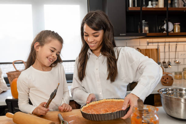 istock Mother and little daughter baking together in a home kitchen making a pie 1369212016