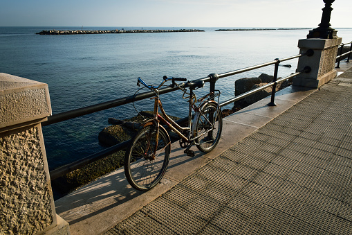 An old rusty bycicle was left near on the seaside promenade.