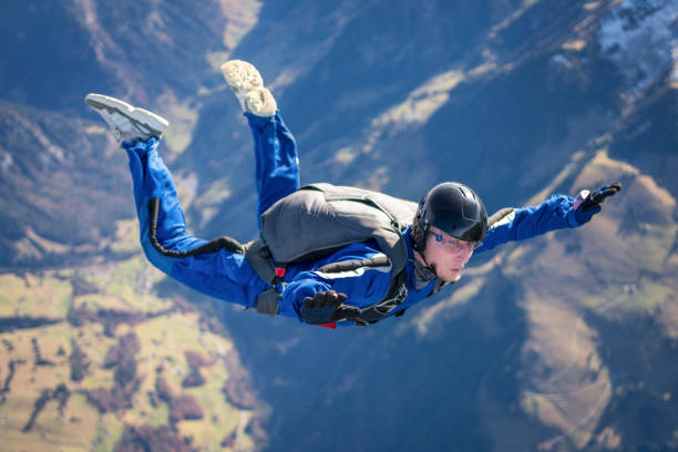 skydiver falls through clear skies, aerial flight - mountain drop europe switzerland imagens e fotografias de stock