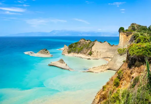 Photo of Cape Drastis cliffs near Sidari and Peroulades on Corfu island in Greece. Famous rock formations with small beach and rugged coastline. Popular Greek destination for summer vacation.