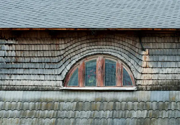 Small semi-circular mansard window of old building in Kamianets-Podilskyi Ukraine