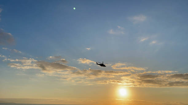 istock helicopter flies low over a beach in winter at sunset time 1369218694