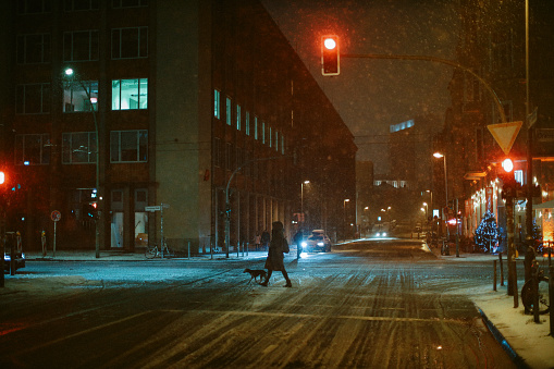 Man walking alone down a city street sidewalk on a foggy night. in Kingston, Ontario, Canada