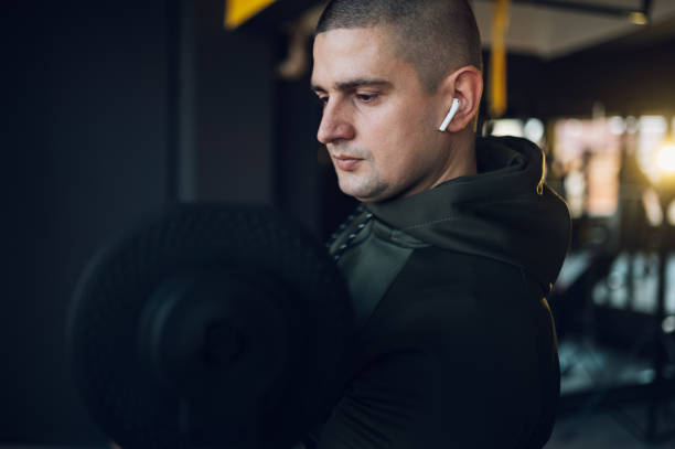 istock Man training in the gym and lifting dumbbells 1369224989