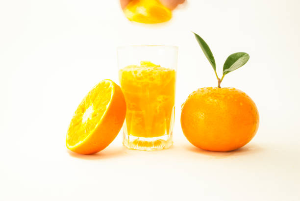 istock Orange fruit is divided into pieces. Fresh looking yellow fruit on white background. Hand holding orange fruit in a glass with vitamins focus on specific points. concept and healthy , space for text 1369227682