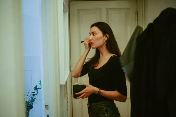 istock young woman putting make up in her apartment 1369231361