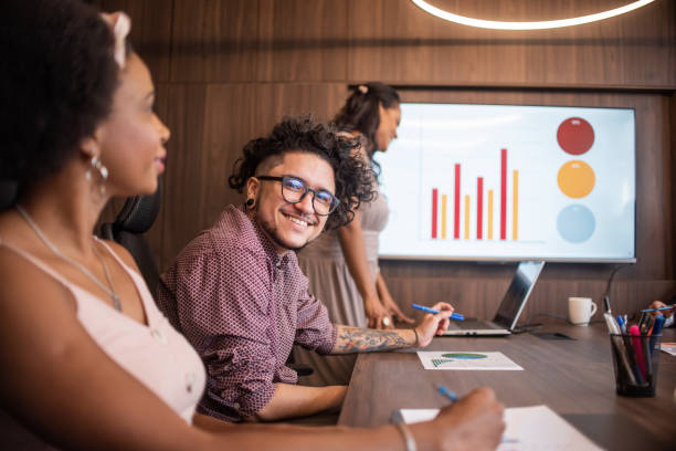 Trans man at a business meeting Trans man and black businesswoman at a business meeting transgender person in office stock pictures, royalty-free photos & images