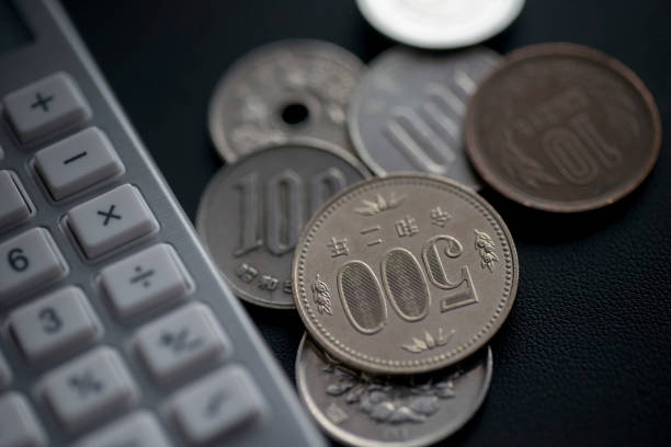 Calculators and Japanese pennies. Calculators and Japanese pennies. Images of low wages and low hourly wages. money shortage stock pictures, royalty-free photos & images