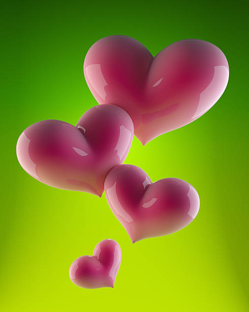 Four pink hearts on green stock photo
