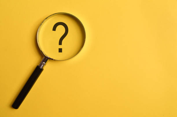 istock Top view of magnifying glass and question mark isolated on yellow background. 1369235021