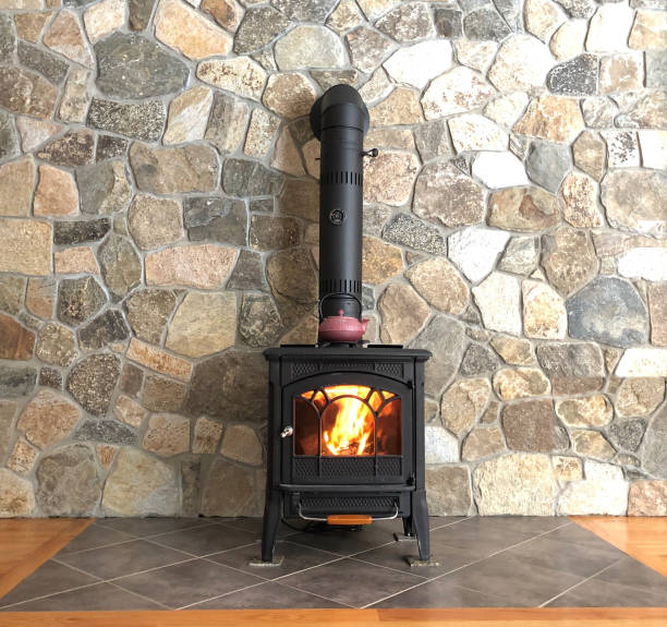 Wood Stove with Black Pipe Against Stone Wall Rustic Background