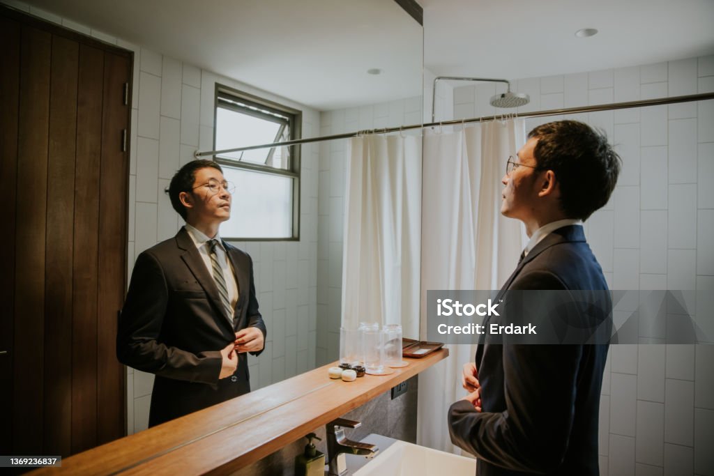 Prod of himself, confident Businessman ready to go to meeting with customer. Businessman checking his grooming, preparing to go to work, meeting with customer at the office. Mirror - Object Stock Photo