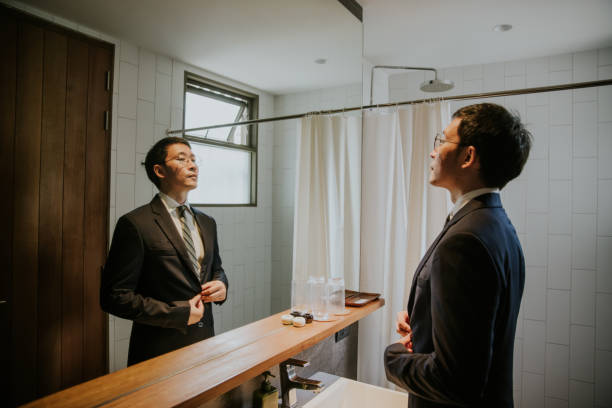 Prod of himself, confident Businessman ready to go to meeting with customer. Businessman checking his grooming, preparing to go to work, meeting with customer at the office. man adjusting tie stock pictures, royalty-free photos & images