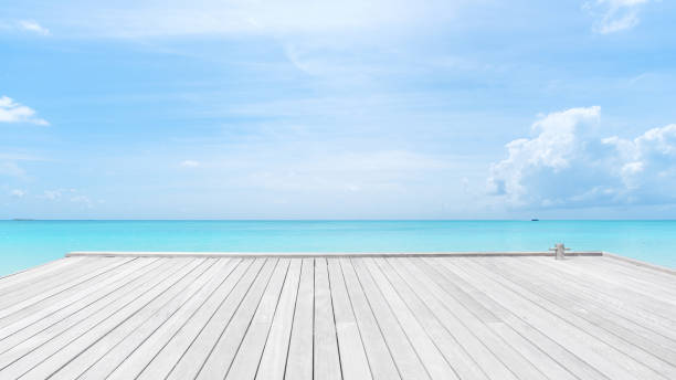 澄んだ空の背景を持つターコイズブルーの海の木製桟橋 - 桟橋　無人 ストックフォトと画像