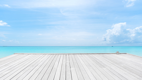 Wooden jetty on turquoise sea with clear sky background