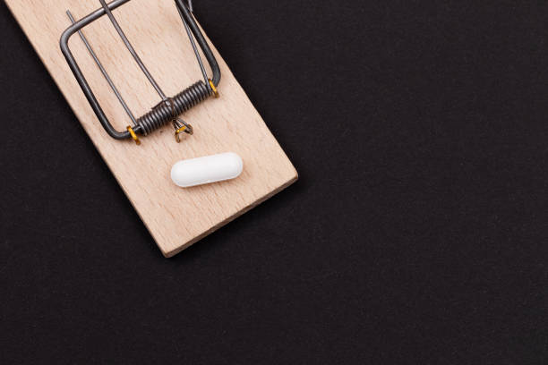 istock White Pill in Wooden Mousetrap - Pharmaceutical Addiction 1369243379