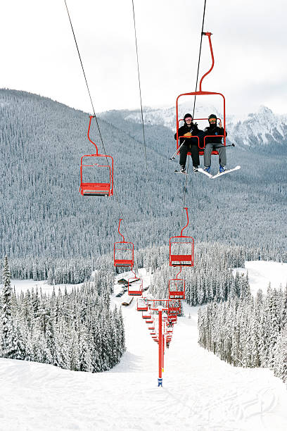shadows on the snow of two snowboarders who go up the mountain on a ski lift. healthy lifestyle, joint outdoor recreation on a winter day