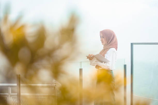 istock girl in hijab on balcony 1369247635