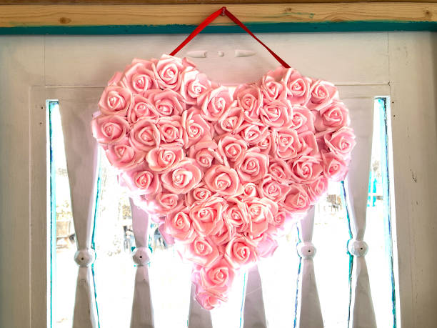istock Valentine's Day: Pink Rose Heart Wreath on Retro Door 1369249437