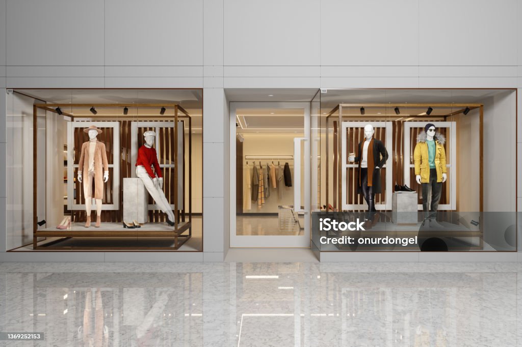Exterior Of Clothing Store With Women's And Men's Clothing On Mannequins Displaying In Showcase. Store Stock Photo